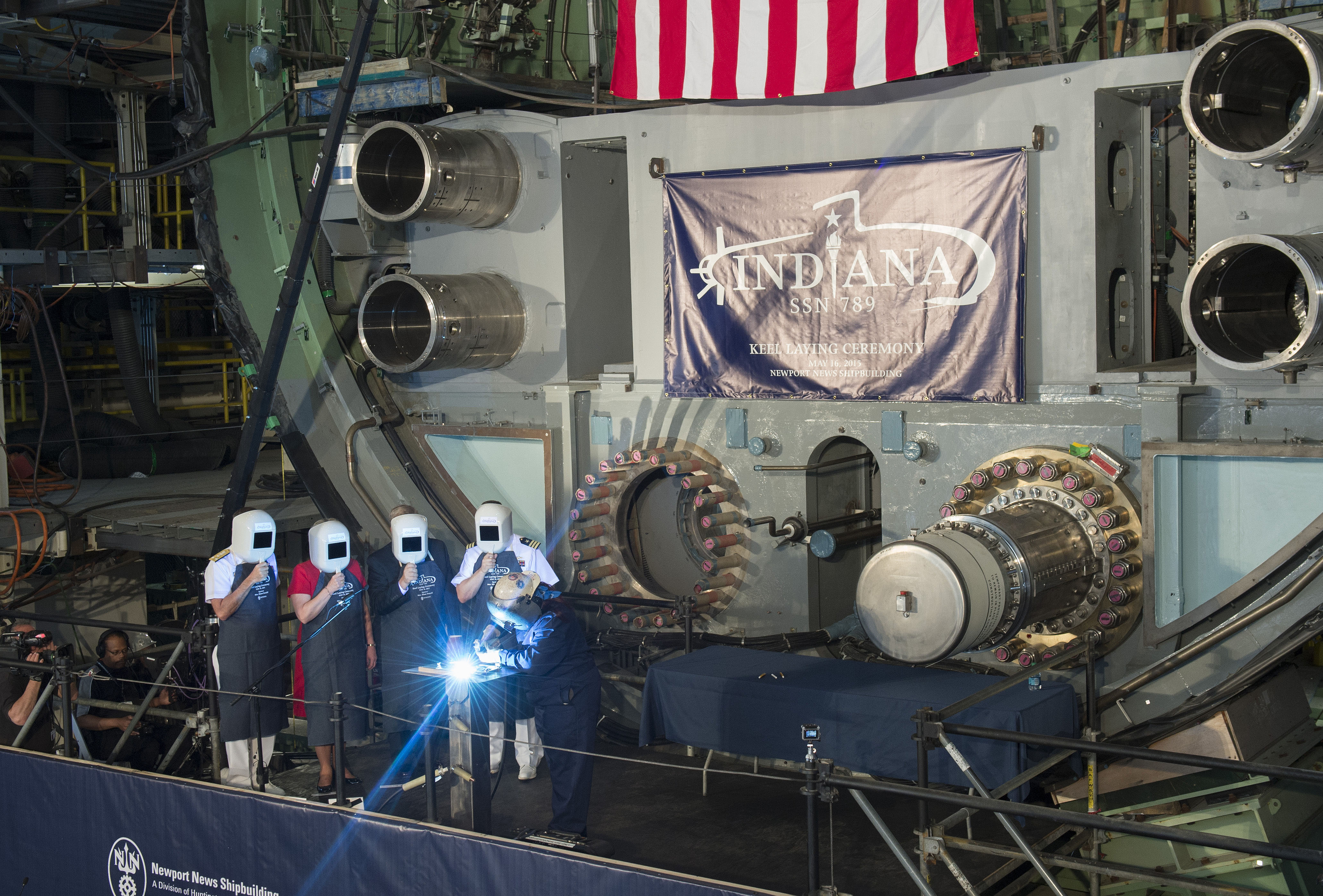 Heather Johnson carves the initials of ship's sponsor Diane Donald on a metal plate during the keel laying ceremony for the future Virginia-class attack submarine Indiana (SSN 789).